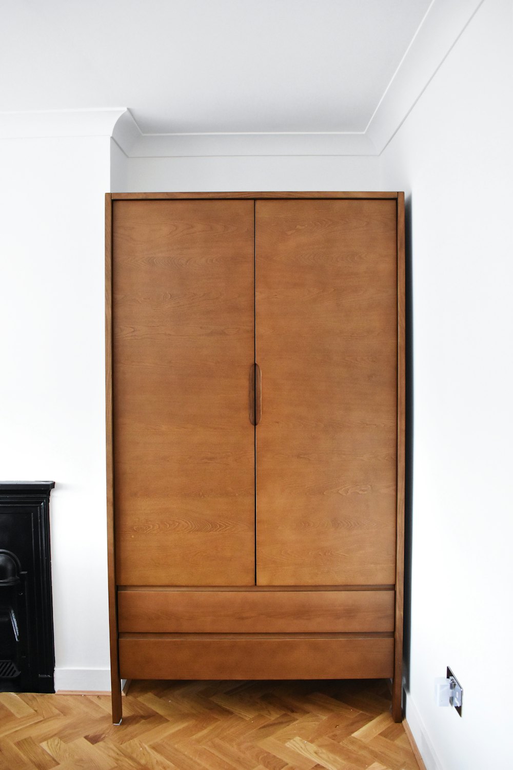 A closed wooden cabinet in a bright room