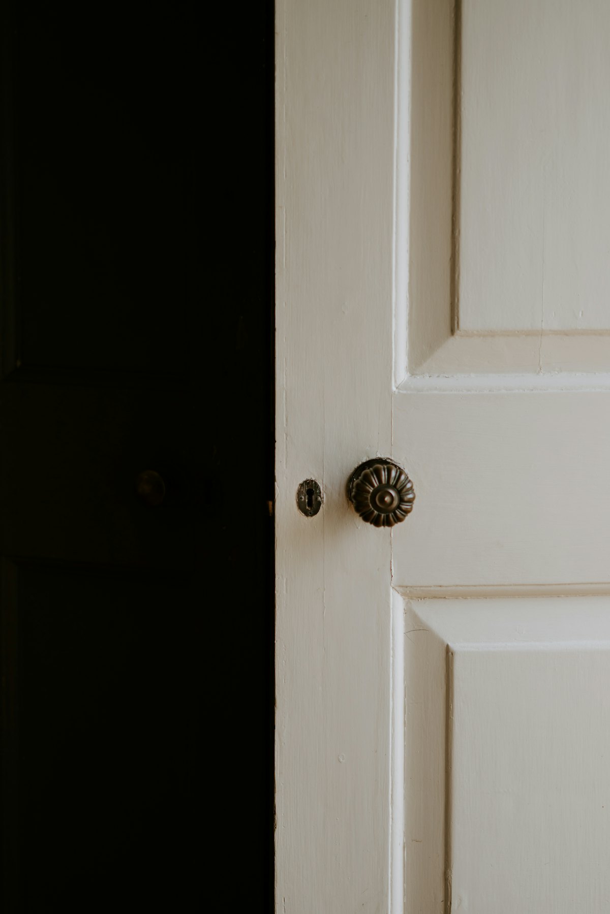 A white door left slightly open onto a dark room